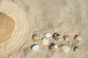 Hut und Muscheln auf das Sand foto