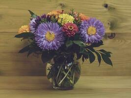 Bild von Vase mit schön Blumen auf hölzern Hintergrund. foto