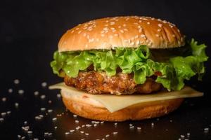 lecker gegrillter hausgemachter Burger mit Rindfleisch, Tomate, Käse, Gurke und Salat foto
