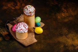 Osterkuchen und bunte Eier auf dunklem Hintergrund foto