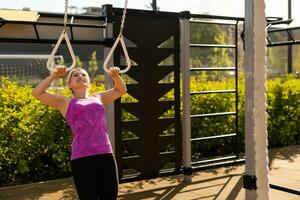 Frau Arbeiten aus im Fitnessstudio auf Ausrüstung draußen haben Spaß foto