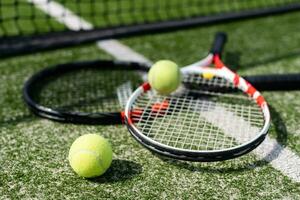 ein Tennisschläger und ein neuer Tennisball auf einem frisch gestrichenen Tennisplatz foto