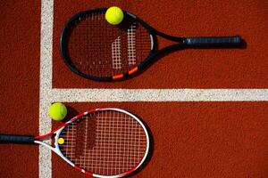 ein Tennisschläger und ein neuer Tennisball auf einem frisch gestrichenen Tennisplatz foto