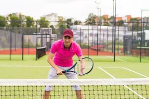 männlich Tennis Spieler beim das Gericht suchen glücklich foto