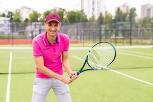 männlich Tennis Spieler beim das Gericht suchen glücklich foto