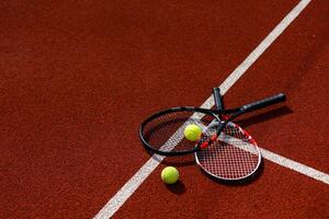 ein Tennisschläger und ein neuer Tennisball auf einem frisch gestrichenen Tennisplatz foto