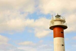 ein rot und Weiß Leuchtturm mit ein Blau Himmel Hintergrund foto