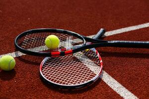 ein Tennisschläger und ein neuer Tennisball auf einem frisch gestrichenen Tennisplatz foto