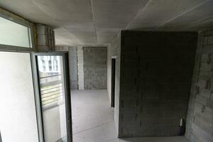 ein Neu unvollendet Wohnung Zimmer mit das nackt Backstein Wände ohne Dekoration. foto