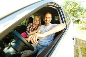 glücklich jung Mann und Frau im ein Auto genießen ein Straße Ausflug auf ein Sommer- Tag. foto