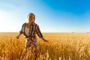 Frau im ein Weizen Feld auf das Hintergrund von das Rahmen Sonne foto