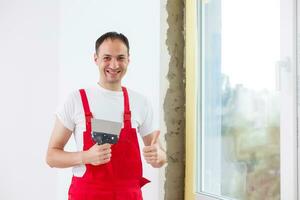 Reparatur im das Pisten von das Fenster. das Prozess von bewirbt sich ein Schicht von Gips auf das Seiten von das Fenster. foto