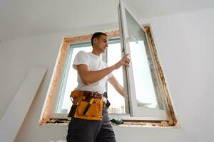 männlich industriell Baumeister Arbeiter beim Fenster Installation im Gebäude Konstruktion Seite? ˅ foto