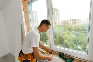 männlich industriell Baumeister Arbeiter beim Fenster Installation im Gebäude Konstruktion Seite? ˅ foto