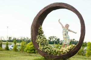 schön jung Frau im nett Kleid posieren auf bunt Mauer von Blumen. Mode Foto, nett Haar, groß Lächeln foto