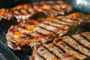 rohes Ribeye-Steak mit Kräutern und Gewürzen, auf Grillpfanne braten foto