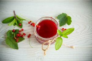 Süss Sommer- Marmelade von reif rot Johannisbeeren im ein Krug foto