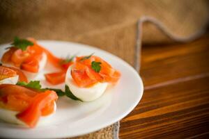 Hälften von gekocht Eier mit Stücke von gesalzen Lachs foto