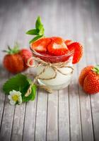 Süss hausgemacht Joghurt mit Erdbeere Marmelade und frisch Erdbeeren im ein Glas Tasse foto