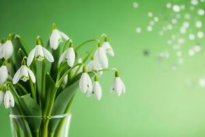 ai generiert ein Strauß von Schneeglöckchen im ein transparent Tequila Glas. spritzt von Wasser auf Blütenblätter. zuerst Frühling Blumen. Wald. Hallo Frühling. Damen Tag Konzept. Grün verwischen Hintergrund. generativ ai. foto