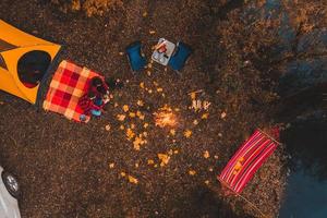 Draufsicht von oben auf den Herbstcampingplatz mit Zeltauto Hängematte Lagerfeuer foto