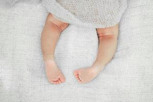 neugeborene babybeine auf dem bett. süßes kleines Baby liegt auf dem Bett foto