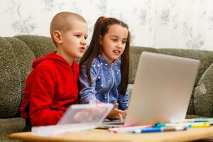 Entfernung Lernen online Bildung. Schule Junge und Mädchen studieren beim Zuhause mit Laptop Notizbuch und tun Hausaufgaben. Sitzung beim ein Tabelle foto