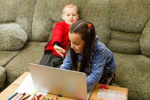 Entfernung Lernen online Bildung. Schule Junge und Mädchen studieren beim Zuhause mit Laptop Notizbuch und tun Hausaufgaben. Sitzung beim ein Tabelle foto