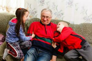 Großvater verbringt Zeit mit Enkelkinder im das Leben Zimmer foto