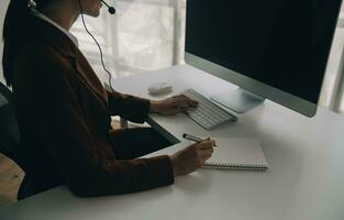 schön weiblich Anruf Center Operator Arbeiten auf Computer im Büro foto