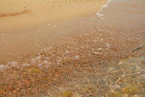 sonnig Strand von Meer, See, Ozean mit Wasser, Welle mit Welligkeit und Sand. sonnig Tag. entspannen, Urlaub, Natur foto