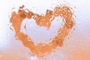 Pfirsich Flaum Herz unter Glas Oberfläche mit Wasser Tropfen schließen. Valentinsgrüße Hintergrund, foto