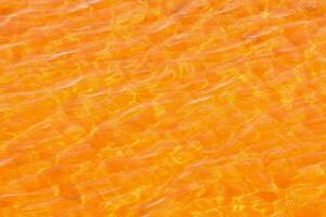 Orange Wasser mit Wellen und Sonnenlicht auf es foto