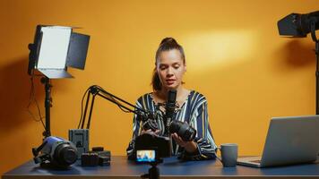 Inhalt Schöpfer Herstellung ein Kamera Linse Vergleich im ihr Fachmann Studio Satz. Inhalt Schöpfer Neu Medien Star Influencer auf Sozial Medien reden Video Foto Ausrüstung zum online Internet Netz Show