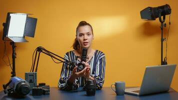 Sozial Medien Star Überprüfung zwei Kamera Linsen im ihr Fachmann Studio. Inhalt Schöpfer Neu Medien Influencer reden Video Foto Ausrüstung zum online Internet Netz Show