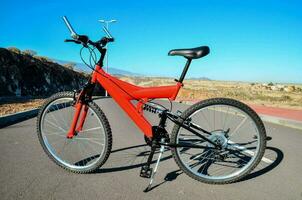 ein rot Berg Fahrrad geparkt auf das Straße foto