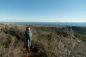 Frau überlegt das Landschaften von das garraf natürlich Park während Gehen das Wege von ein Berg. foto