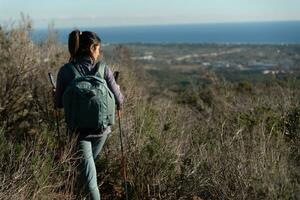 Frau überlegt das Landschaften von das garraf natürlich Park während Gehen das Wege von ein Berg. foto