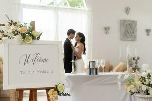 herzlich willkommen zu Hochzeit Zeichen mit Braut und Bräutigam im Hintergrund foto