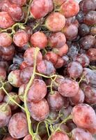 schließen oben von roh organisch Süss rot Trauben Hintergrund, Wein Trauben Textur, gesund Früchte rot Wein Trauben Hintergrund, oben Aussicht foto