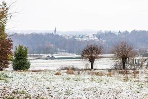 erster Schnee auf den Hügelstädten. zwischen Herbst und Winter foto