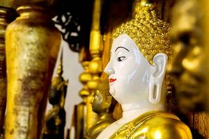 Nahansicht und Seite Aussicht uralt golden Buddha Statue von birmanisch Kunst im Heiligtum beim wat phra Das haripunchai lumphun Thialand. foto