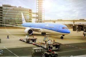 Bangkok Stadt, Thailand, 2018 - - Blau Flugzeug von klm königlich Niederländisch Fluggesellschaft ankommen beim Kansai International Flughafen, Japan mit Blau Himmel und Sonne, Linse Fackel Hintergrund foto