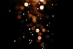 verschwommen Girlande Beleuchtung auf ein dunkel Hintergrund. festlich Weihnachten und Neu Jahr Hintergrund. Sanft Fokus. Bild getönt im Farbe von das Jahr 2024 - - Pfirsich Flaum foto