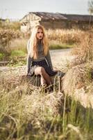 schöne junge blonde Frau im ländlichen Hintergrund foto