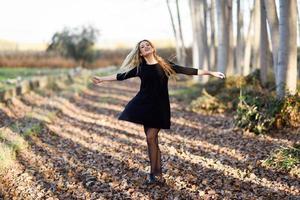 junge blonde Frau tanzt im Pappelwald
