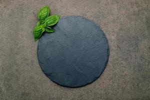 leere Pizzaplatte für hausgemachtes Backen auf dunklem Beton. Lebensmittelrezeptkonzept auf dunkler Steinhintergrundbeschaffenheit mit Kopienraum.