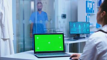 Grün Attrappe, Lehrmodell, Simulation auf Arzt Laptop im Krankenhaus und Krankenschwester Öffnung Kabinett Glas Tür. foto