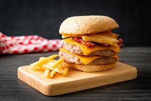 Schweinefleischburger mit Käse, Speck und Pommes frites foto