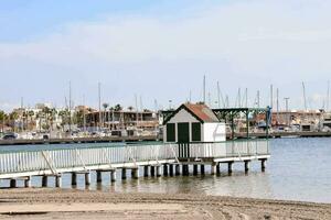 ein Seebrücke mit ein klein Haus auf es im Vorderseite von Boote foto